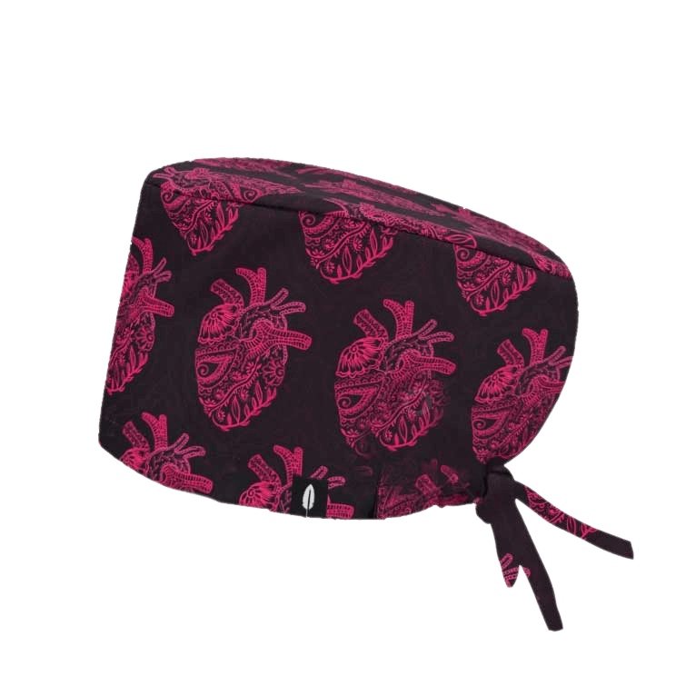 Gorro quirúrgico HENNA con diseño de corazones en tonos fucsias sobre fondo oscuro, fabricado en poliéster transpirable.