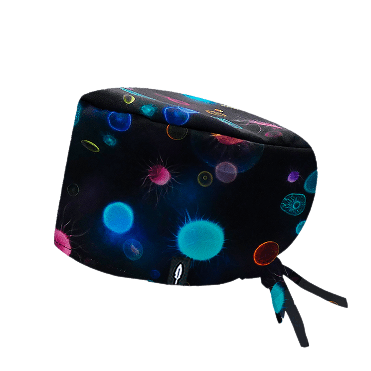 Gorro quirúrgico Bacteroidetes con diseño de bacterias en tonos fluorescentes (azul, rosa, naranja y verde) sobre un fondo oscuro. Fabricado en poliéster transpirable, ideal para microbiólogos que buscan comodidad y estilo en su entorno laboral.