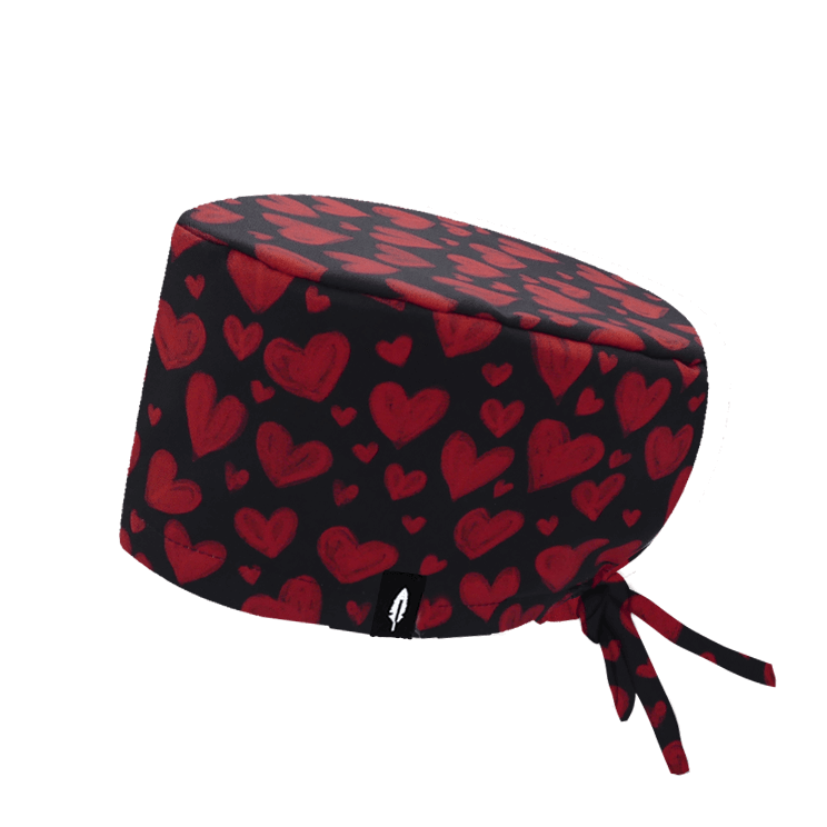 Gorro quirúrgico con estampado de corazones rojos sobre fondo negro, ideal para profesionales sanitarios con cabello largo.