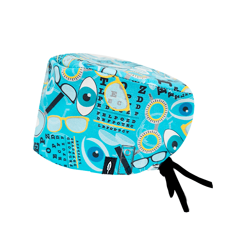 Gorro de quirófano VISION para oftalmólogos, con diseño de ojos, tablas optométricas y gafas en tonos azul y amarillo. Fabricado en algodón con sistema Click & Mask.