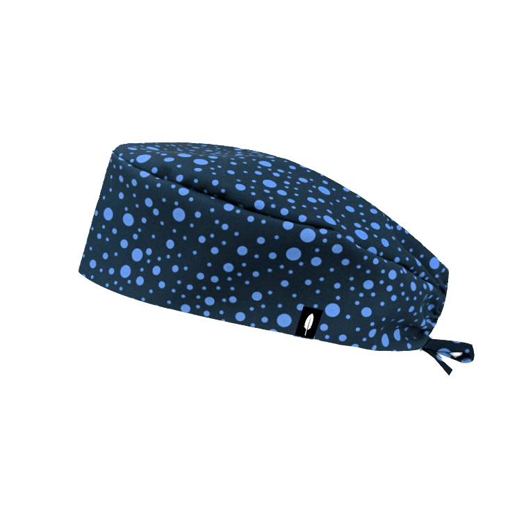 Gorro quirúrgico HUGH de Robin Hat con diseño de burbujas azules sobre fondo azul marino. Elegancia y confort para jornadas intensas