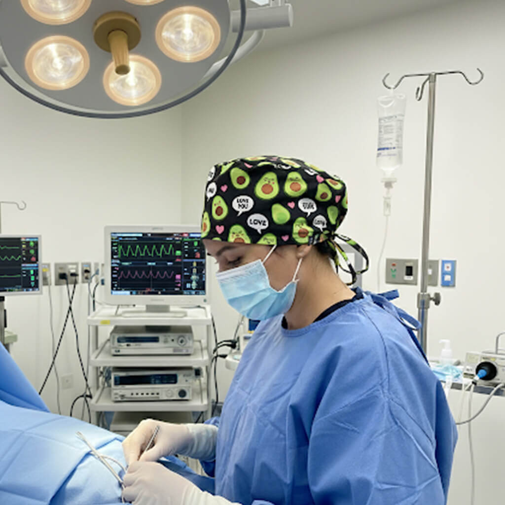 Profesional médico en quirófano usando gorro quirúrgico aguacates Robin Hat durante intervención quirúrgica