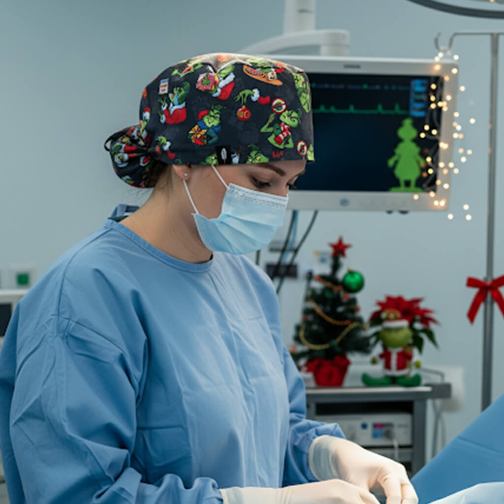 Profesional sanitaria en quirófano con gorro navideño negro Robin Hat con Grinch y personajes navideños