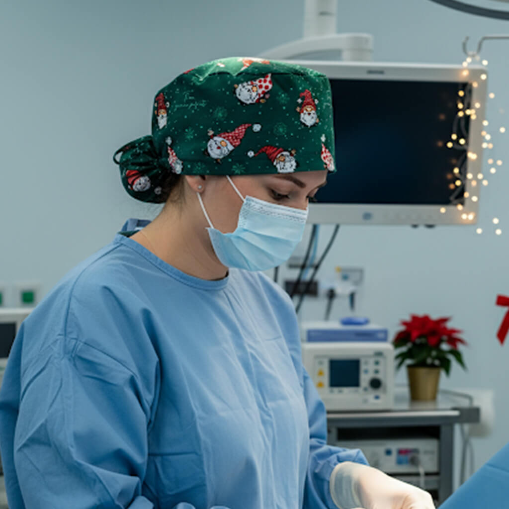Profesional sanitaria en quirófano con gorro navideño verde Robin Hat con Santa Claus y mascarilla quirúrgica