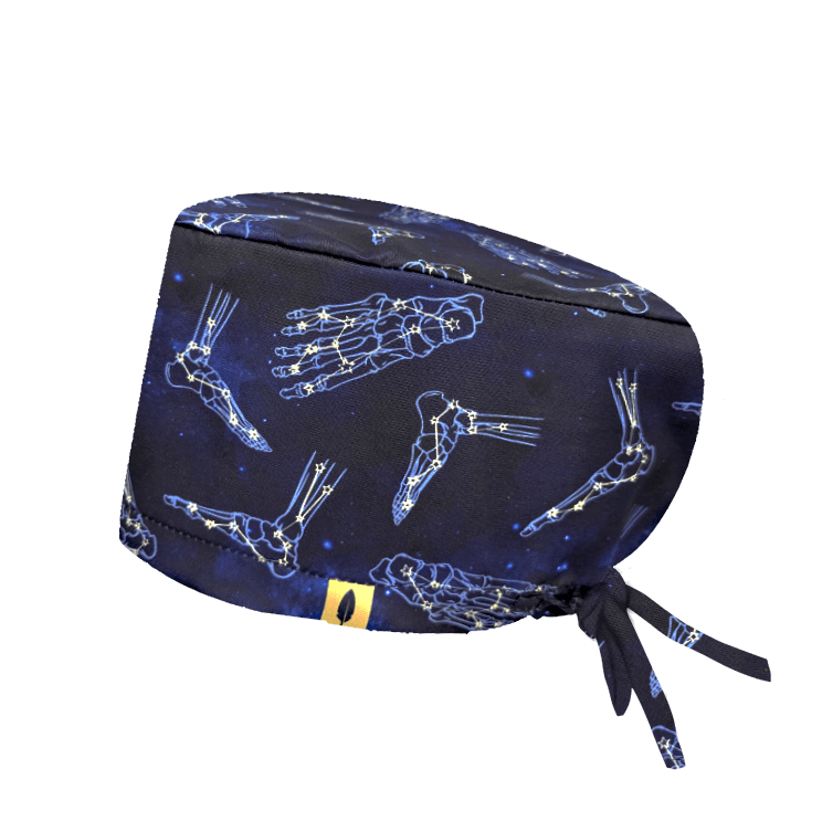 Gorro quirúrgico ASTROFOOT con constelaciones en forma de pies sobre azul marino. Tejido técnico ideal para quirófano y sala blanca.