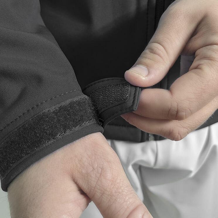 Chaqueta softshell sanitaria negra, con cierre frontal robusto, ajuste en muñecas y bolsillos amplios, diseñada para médicos y personal de salud en hospitales.