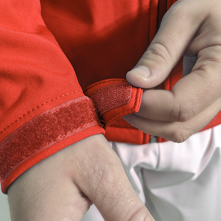 Chaqueta sanitaria roja softshell, equipada con cierre duradero, ajustes en las mangas y bolsillos prácticos, perfecta para uso diario en entornos de salud.