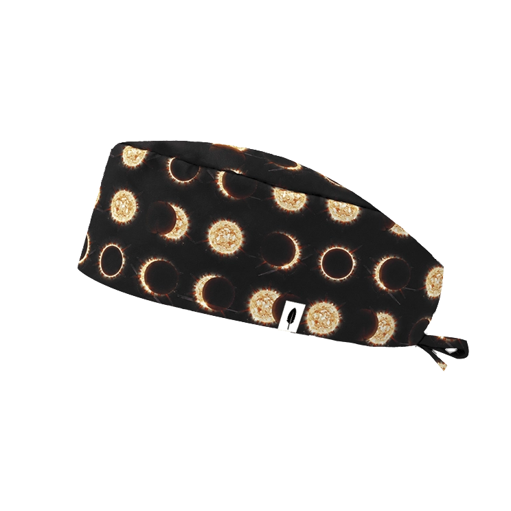 Gorro quirúrgico pelo corto ECLIPSE SOLAR de Robin Hat con eclipses y coronas solares doradas sobre fondo negro, diseño espacial llamativo