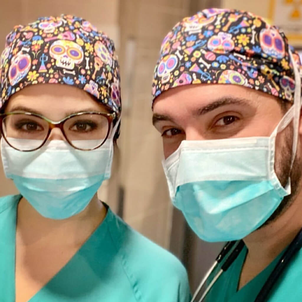 Equipo sanitario de médico y enfermera usando gorros quirúrgicos CATRINAS de Robin Hat con diseño del Día de los Muertos con calaveras y símbolos tradicionales mexicanos en colores vibrantes, confeccionados en algodón de alta calidad durante jornada laboral hospitalaria