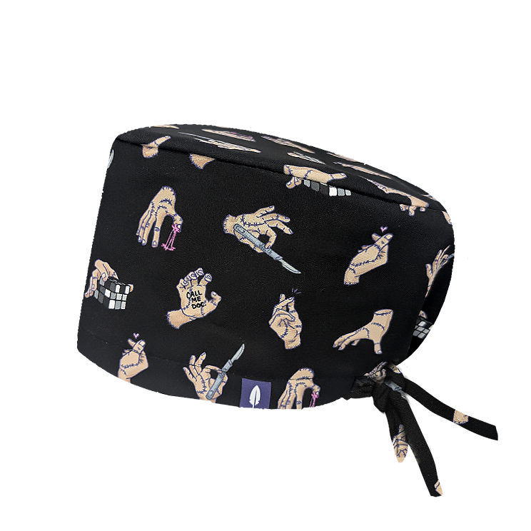 Gorro quirúrgico Robin Hat con estampado de mano Cosa sobre fondo negro, diseño divertido con gestos y accesorios para profesionales sanitarios que buscan originalidad en el quirófano