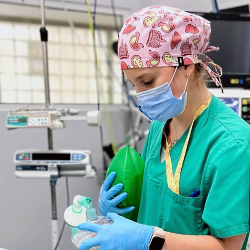 Enfermera en area de hospitalizacion con gorro quirurgico Robin Hat Digestive en tonos rosas, estampado anatomico de estomago intestinos higado pancreas, ideal para gastroenterologia y cirugia digestiva