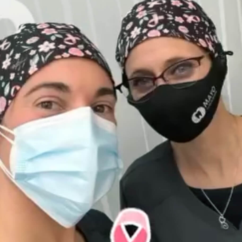 Dúo de profesionales sanitarias con gorros quirúrgicos Margaret Foti negros con flores rosas - Robin Hat