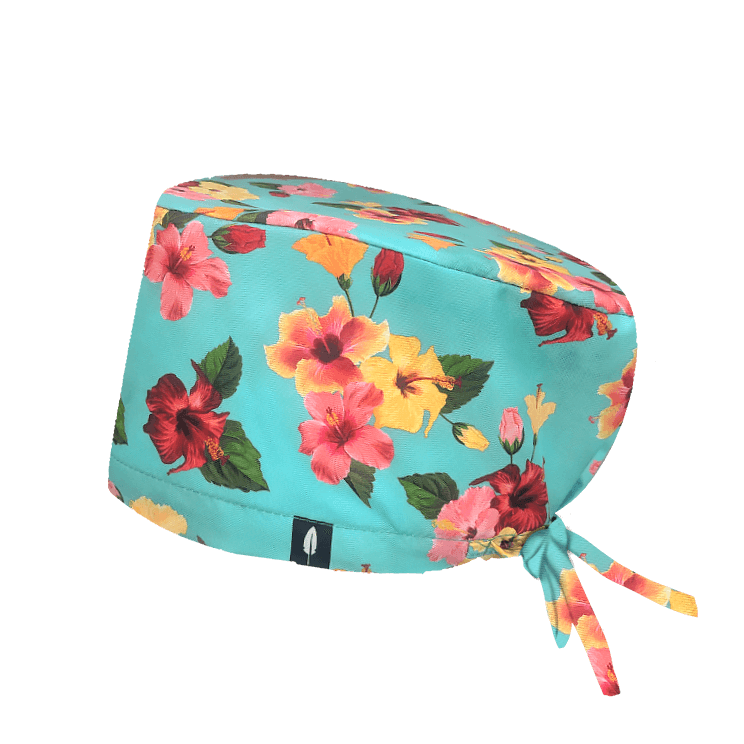 Gorro quirúrgico HIBISCUS de Robin Hat con flores de hibisco sobre fondo turquesa. Tejido técnico ideal para quirófano y sala blanca