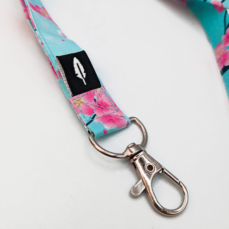 Lanyard Sakura completo con diseño floral y clip metálico.